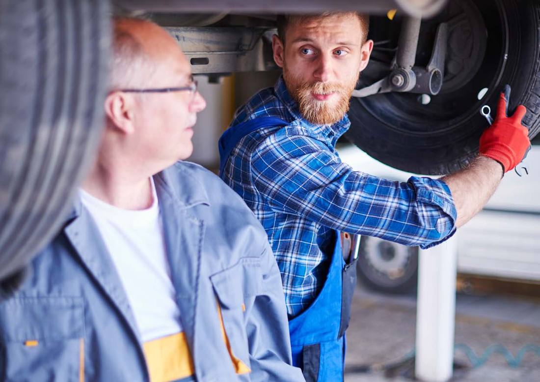 Two mechanics inspecting a wheel